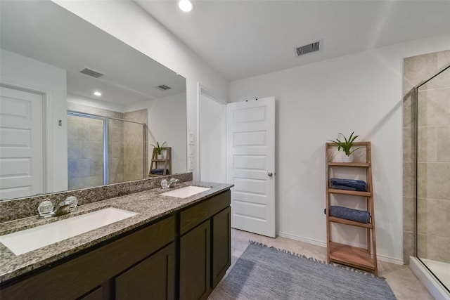 bathroom with an enclosed shower, vanity, and tile patterned flooring