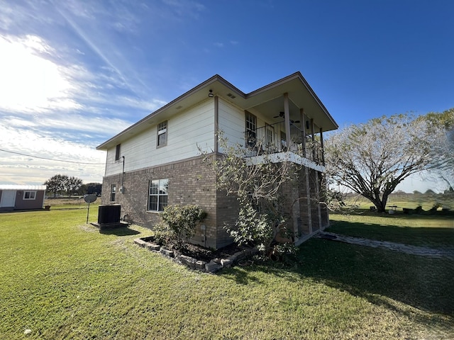 view of property exterior featuring a balcony, a yard, central AC unit, and ceiling fan