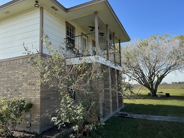 view of home's exterior with ceiling fan, a yard, and a balcony