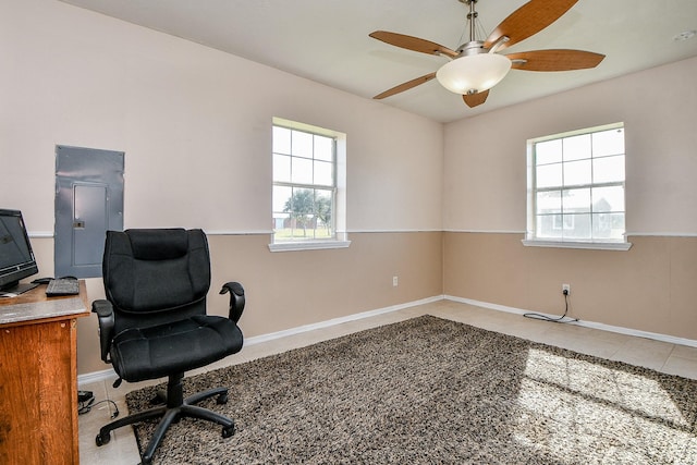 tiled office space featuring electric panel and ceiling fan