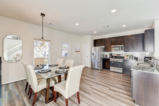 dining space featuring sink and light hardwood / wood-style flooring