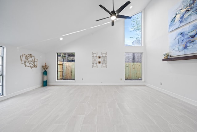 unfurnished living room with ceiling fan, vaulted ceiling, and a healthy amount of sunlight