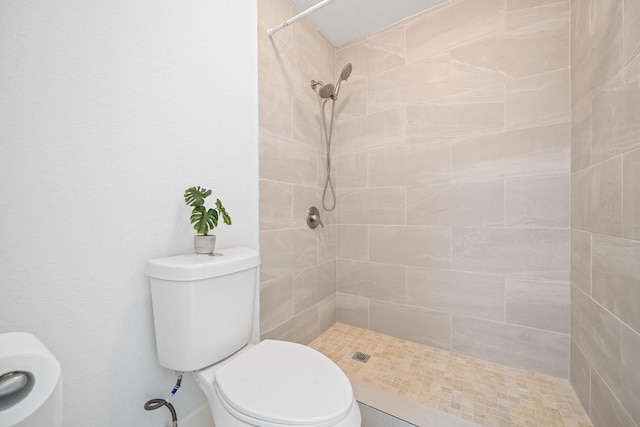 bathroom with toilet and a tile shower