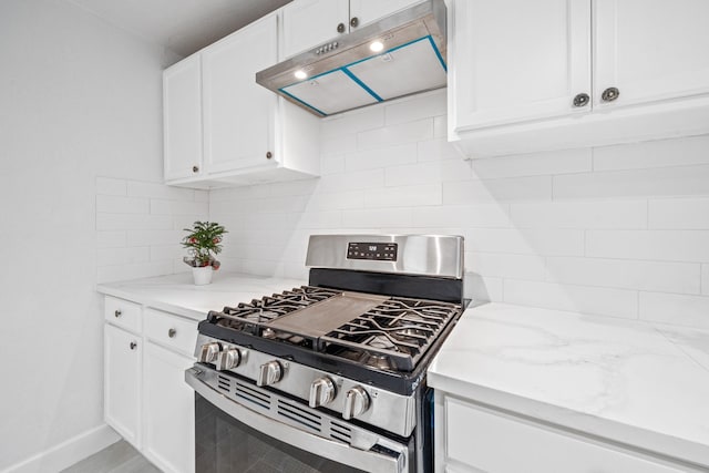 kitchen featuring white cabinetry, gas range, light stone countertops, and backsplash