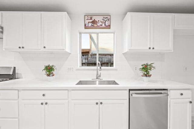 kitchen with white cabinetry, dishwasher, light stone countertops, and sink