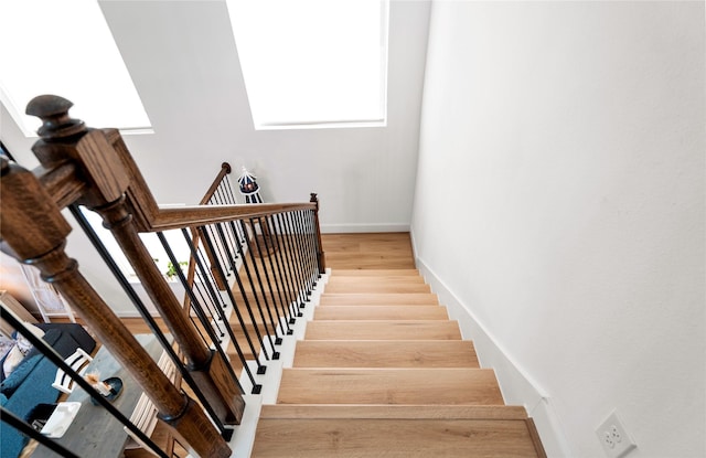 stairs with wood-type flooring and a wealth of natural light