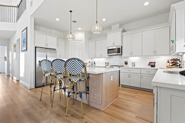 kitchen featuring stainless steel appliances, a kitchen island, and white cabinets