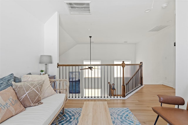 living area featuring vaulted ceiling and light hardwood / wood-style flooring