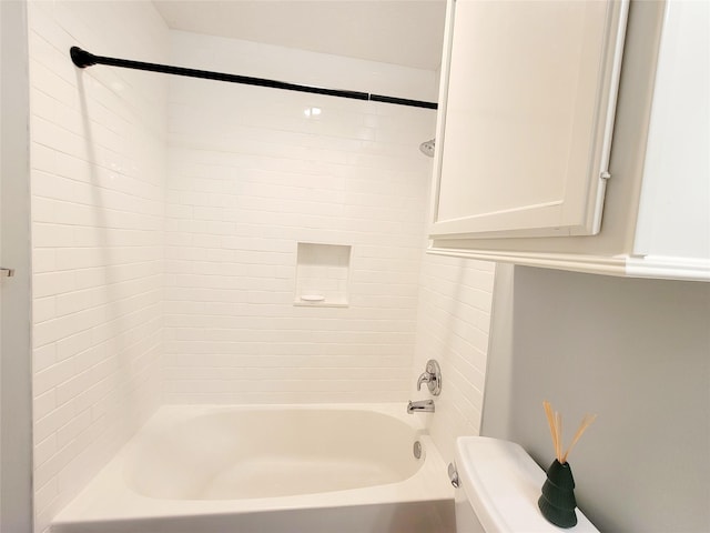 bathroom with toilet and tiled shower / bath