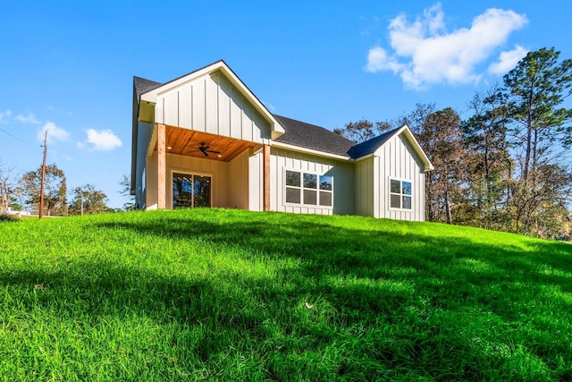 back of property featuring a yard and ceiling fan