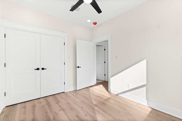 unfurnished bedroom featuring light wood-type flooring, ceiling fan, and a closet