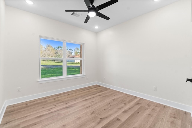 empty room with ceiling fan and light hardwood / wood-style flooring