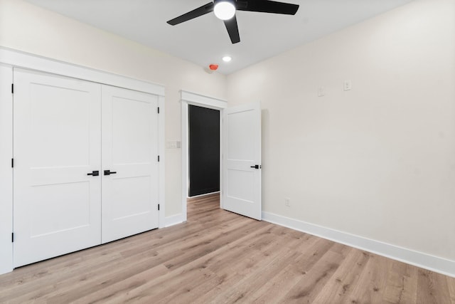 unfurnished bedroom with ceiling fan, a closet, and light wood-type flooring