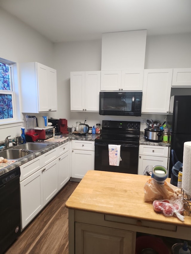 kitchen with butcher block countertops, sink, dark wood-type flooring, black appliances, and white cabinets