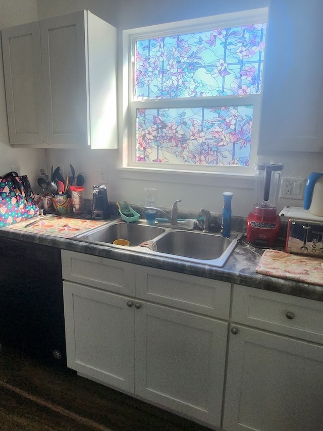 kitchen featuring white cabinetry and sink