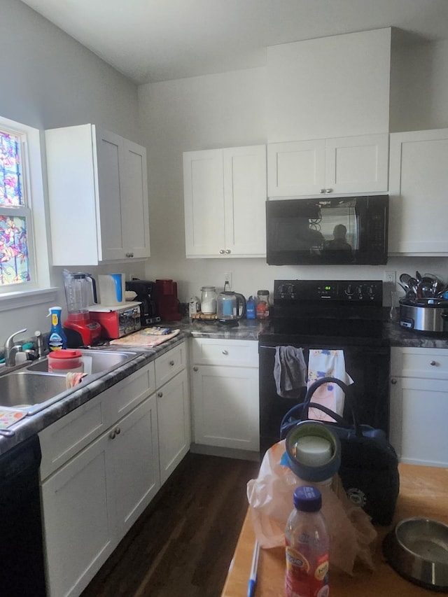 kitchen with sink, dark wood-type flooring, black appliances, and white cabinets