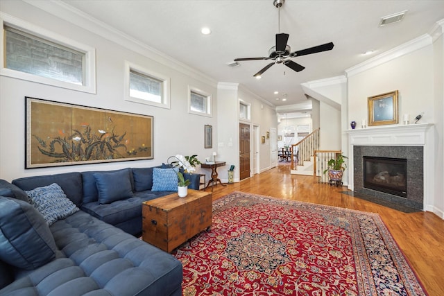 living room with hardwood / wood-style floors, crown molding, a fireplace, and ceiling fan