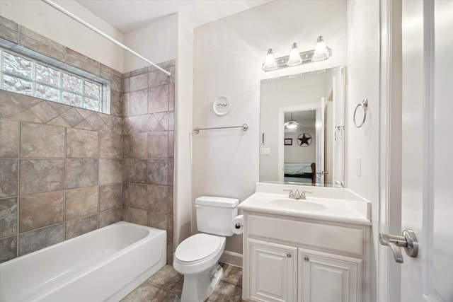 full bathroom with tiled shower / bath, vanity, toilet, and tile patterned floors