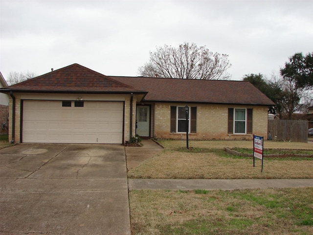 ranch-style house featuring a garage and a front lawn