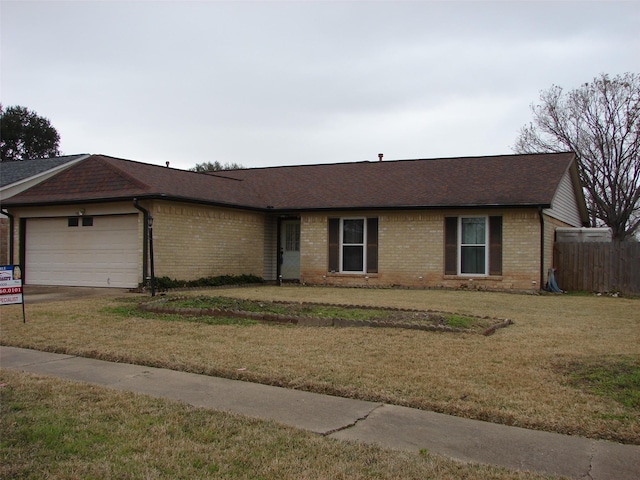 ranch-style house featuring a garage and a front lawn