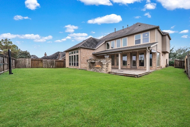 back of property with a patio, a fireplace, and a lawn