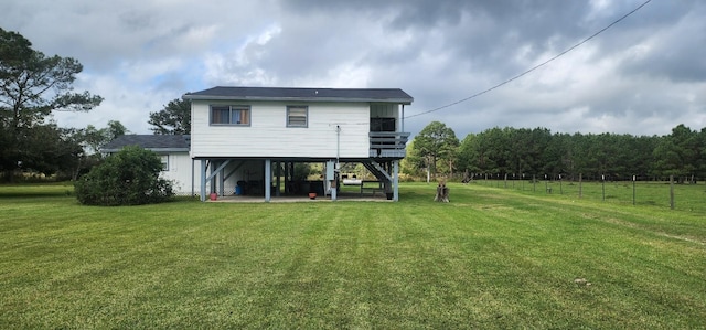 back of property with a lawn and a patio