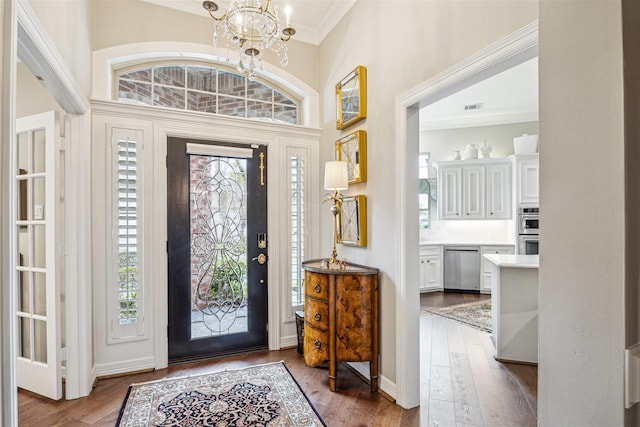 entryway with crown molding, a chandelier, and hardwood / wood-style floors