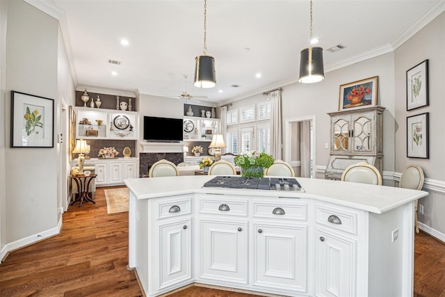 kitchen with dark hardwood / wood-style flooring, white cabinets, a center island, and stainless steel gas stovetop