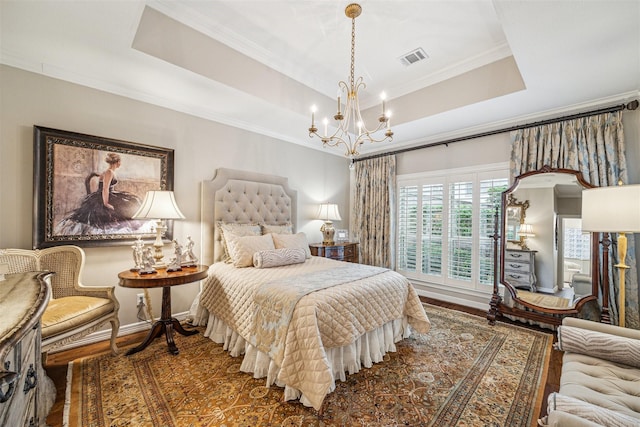 bedroom with dark hardwood / wood-style flooring, a tray ceiling, ornamental molding, and an inviting chandelier