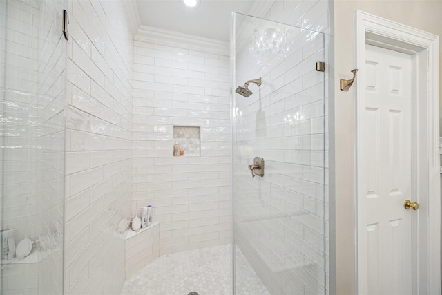 bathroom with ornamental molding and a shower with shower door