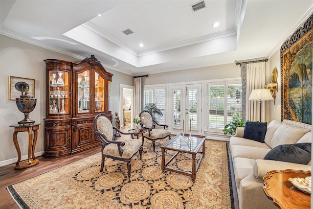 living room featuring crown molding, a tray ceiling, and hardwood / wood-style flooring