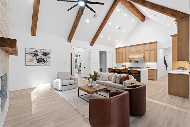 living room with beamed ceiling, a fireplace, high vaulted ceiling, and light hardwood / wood-style flooring