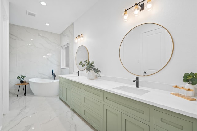 bathroom featuring vanity, a tub, and tile walls