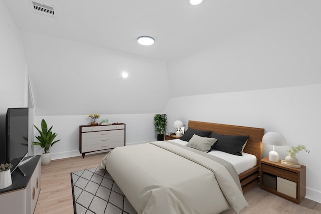 bedroom featuring vaulted ceiling and light hardwood / wood-style floors