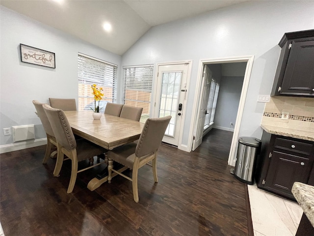 dining room with lofted ceiling and dark wood-type flooring