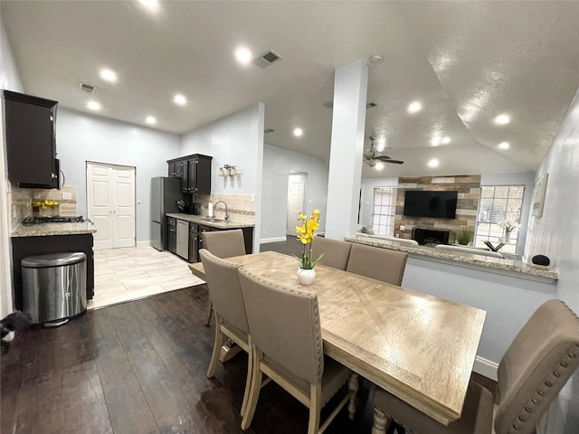 dining area featuring ceiling fan, lofted ceiling, dark hardwood / wood-style flooring, and sink