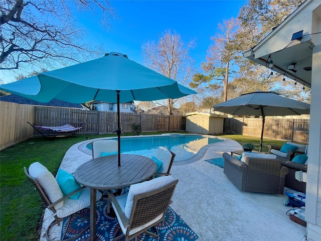 view of pool featuring a shed, a yard, and a patio