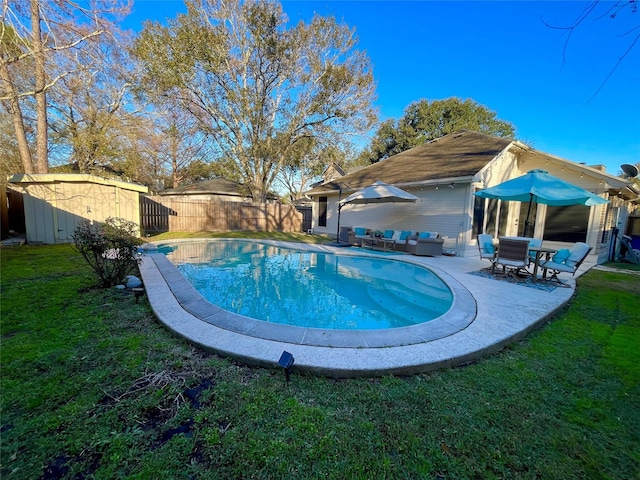 view of pool with a yard, an outdoor hangout area, a patio area, and a storage unit