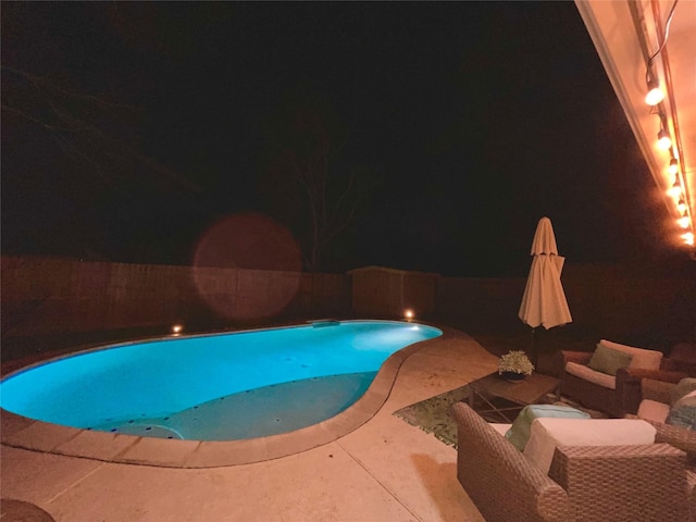 pool at twilight featuring a patio