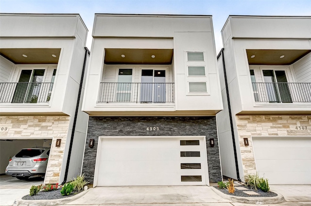 view of front of property featuring a balcony and a garage