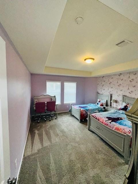 carpeted bedroom with a raised ceiling