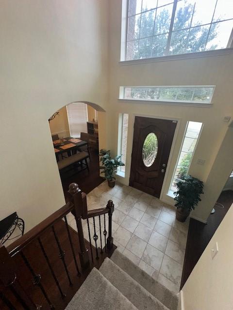 tiled foyer entrance with a towering ceiling and plenty of natural light