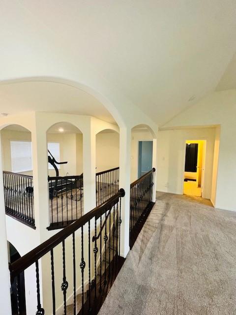 hall with lofted ceiling and carpet flooring