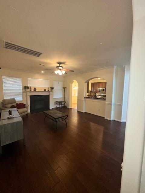 living room with dark wood-type flooring and ceiling fan