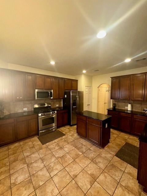 kitchen featuring stainless steel appliances, a kitchen island, and light tile patterned floors