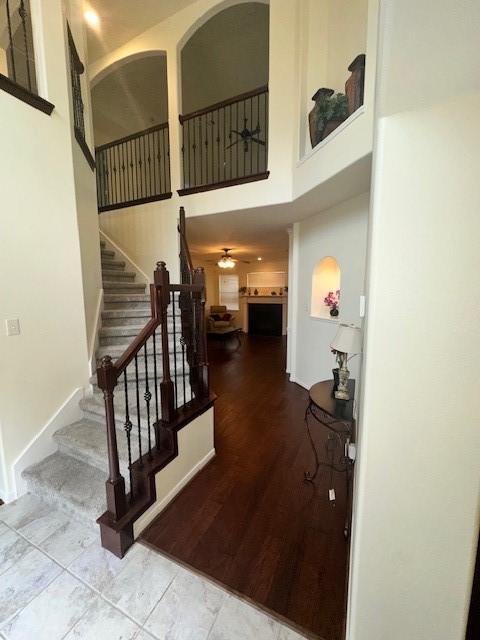 stairs with a towering ceiling and ceiling fan