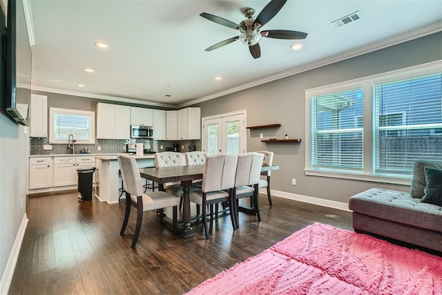 dining space with french doors, sink, ornamental molding, dark hardwood / wood-style flooring, and ceiling fan