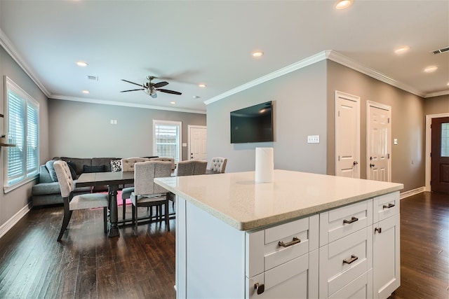 kitchen featuring crown molding, dark wood-type flooring, light stone countertops, and white cabinets