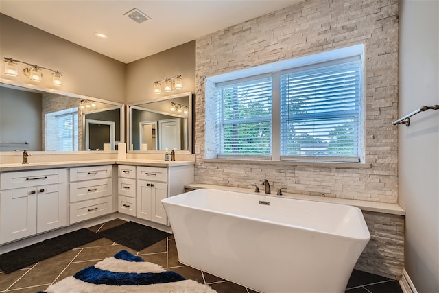 bathroom featuring a bathing tub, tile patterned floors, and vanity