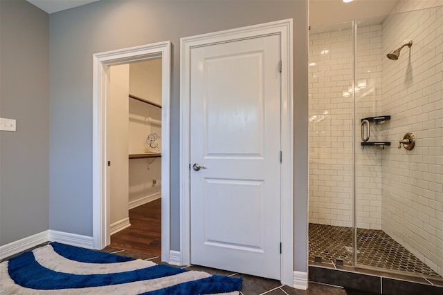 bathroom with an enclosed shower and tile patterned flooring